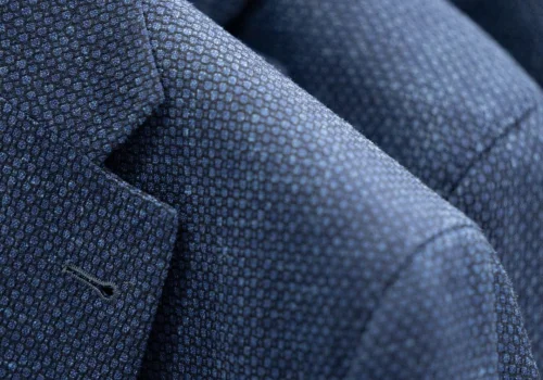 Closeup showing textured fabric in men's suit jacket