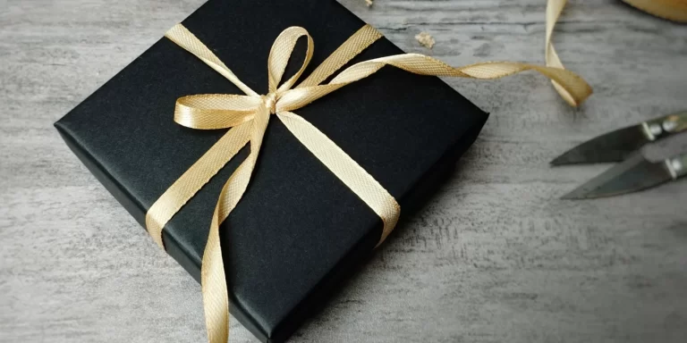 Nicely wrapped gift box with gold ribbon and scissors