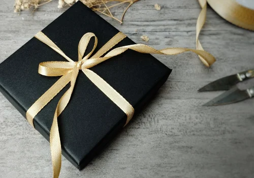 Nicely wrapped gift box with gold ribbon and scissors