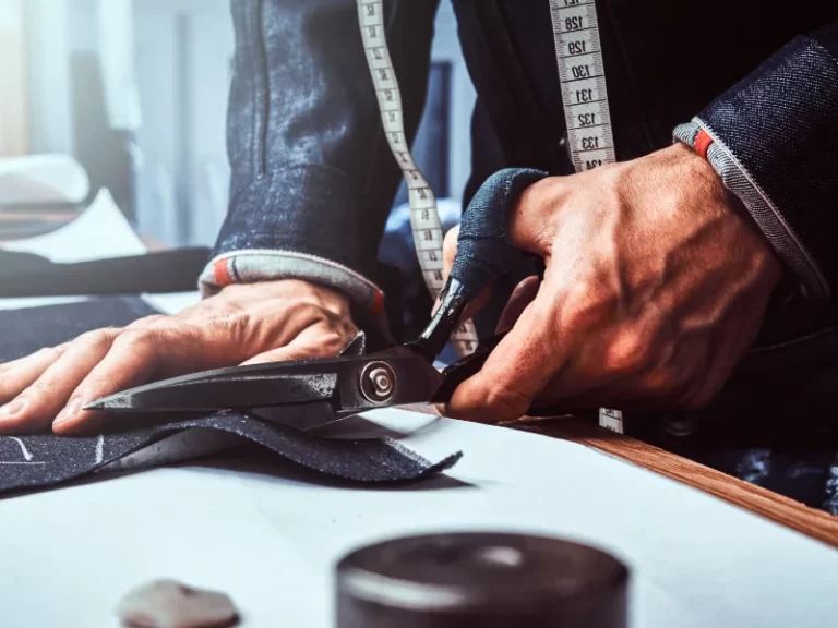 Tailor using scissors to cut material